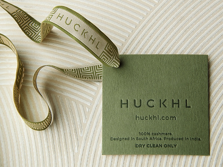 Huckhl ribbon and care card design against patterned background