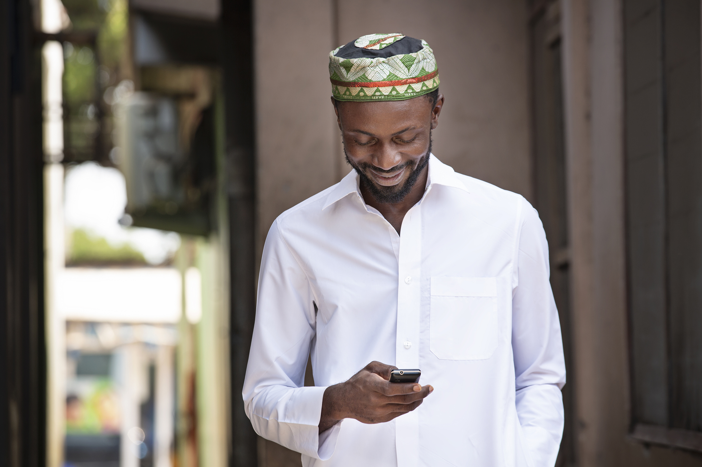 Muslim man looking at his phone on a street in Ghana